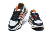 Pair of navy, white, and orange Hermès sneakers viewed from the front.