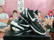 Angled view showing the white side Swoosh, textured black upper, and heel detail.