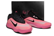 Pair of black-and-pink Nike A'ja Wilson 1 shoes displayed in front of a black shoebox.