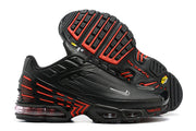 Side and outsole views of black Nike Air Max Plus sneakers with red accents