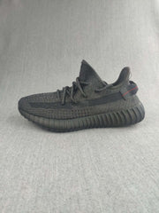 Side profile of a black knit sneaker with a ribbed dark outsole.