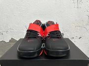 Front view of black basketball shoes with red midfoot straps and red accents
