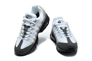 Front and angled view of a pair of grey Nike Air Max 95 TT sneakers