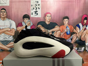Side profile of a black sneaker showing a large white sculpted side section and a red outsole accent.