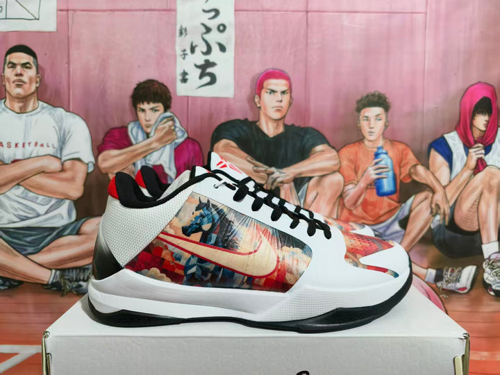 Side view of white, black, and red Nike basketball sneakers with multicolored graphic side panels on a shoe box.