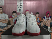Front view showing white perforated uppers, white laces, and red outsole accents.