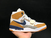 Side profile of the Jordan Legacy 312 sneaker showing the navy Swoosh, tan overlays, elephant-print panel, and midfoot strap.