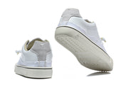 White low-top sneakers shown from the heel and outsole, with gray heel panels and cream-colored soles.