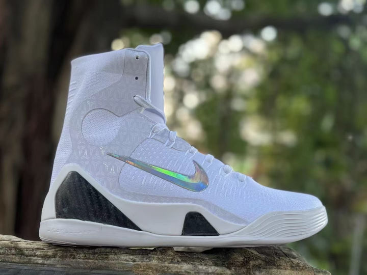 Side view of a white Nike Kobe 9 Elite high-top basketball shoe with an iridescent Swoosh