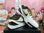 Angled view of the white, black, and gold basketball shoes