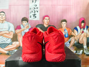 Rear view of red basketball shoes with textured heels and patterned outsoles.