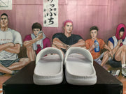 Pair of white Nike slides shown from the rear, with embossed “revive foam” wording on the heel area.