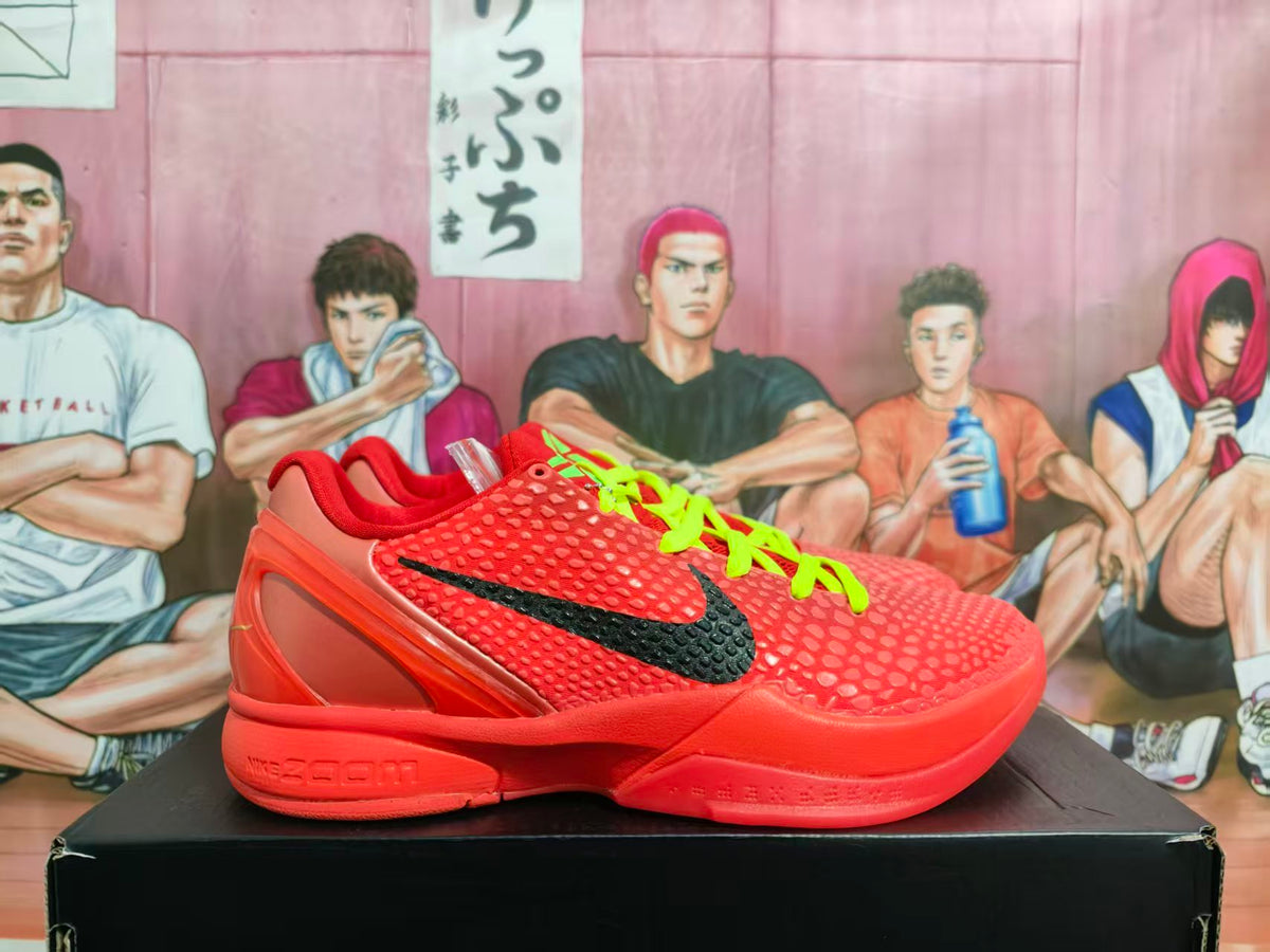 Side view of red Nike Zoom basketball sneakers with black side branding, lime-green laces, and a textured upper on a black box.