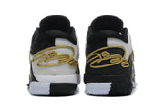 Rear view of the black and white sneakers showing contrasting heel panels and gold decorative detailing.
