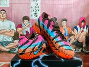 Angled view of the pair showing the colorful upper, brown laces, black accents, and orange outsole.