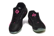 Pair of black basketball shoes viewed from the front, with bright pink tongue logos, white lace accents, and translucent outsoles.