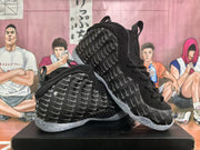 Angled view of the pair displaying the repeated gray graphic pattern, black uppers, and translucent soles.