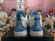 Rear view of white and blue Jordan basketball sneakers with Jumpman heel logos.