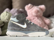 Close side profile of the gray sneaker showing layered panels, patterned upper, contrasting side detail and thick outsole.