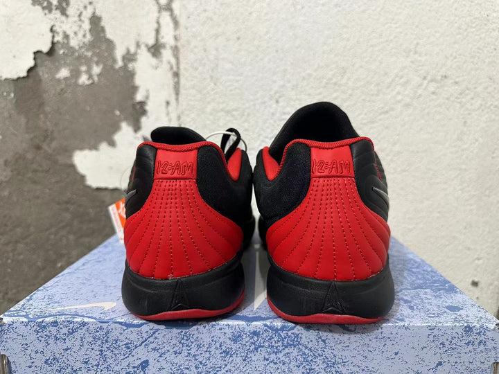 Rear view of black and red Nike basketball shoes showing red stitched heel panels.