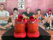 Rear view of red Nike basketball sneakers showing translucent orange-red heel panels, red collars, green accents, and yellow heel detailing.