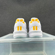 Rear view of the pair showing yellow heel panels, white heel structures, and textured outsole edges.