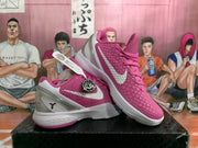 Angled view of two pink and white basketball sneakers displaying the textured uppers, side branding, heel details, and layered midsoles.