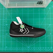Side view of the black sneaker showing the star detail, textured outsole, and Converse-branded hangtag.