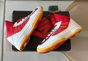 Angled overhead view of the pair showing the red mesh panels, white uppers, and gum-colored outsoles.