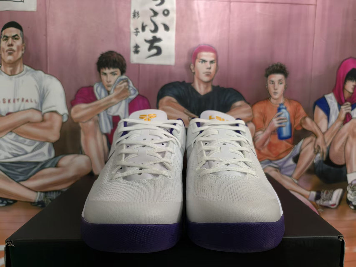 Front view of white Nike basketball sneakers with purple outsoles and yellow tongue accents.