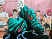 Pair of teal and black Nike basketball shoes shown at an angle.