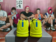 Rear view of yellow Nike Kobe shoes with blue heel accents