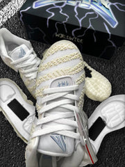 Top-down close-up of the laces, tongue branding, textured upper, and detached sole components.