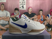 Side profile of a white and blue basketball sneaker with a tan heel, blue side branding, and a speckled midsole.