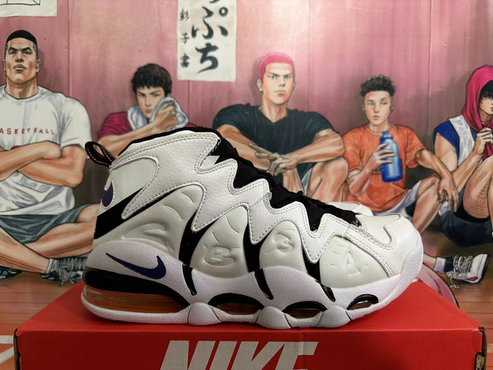 Side view of white and black Nike basketball sneakers with purple Swoosh accents and a visible heel air unit