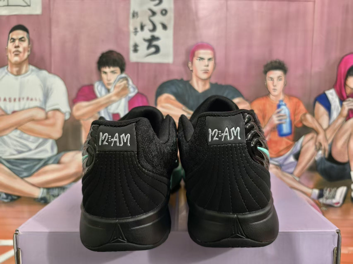 Rear view of black basketball sneakers showing padded heel panels, stitched detailing, and mint-green side accents.