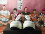 Front view of the white running shoes with black stripe overlays and thick white soles.