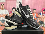 Angled view of two black and white basketball sneakers showing textured uppers, contrasting swooshes, and Nike Zoom branding.