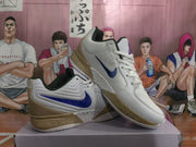 Angled side view showing the blue Nike Swoosh, white upper, tan heel panel and speckled midsole.