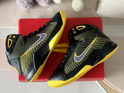 Angled top view showing both sneakers, their yellow outsoles, and black patterned uppers.