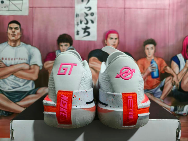 Rear view of white Nike GT basketball shoes with pink and orange-red heel accents on a shoebox.