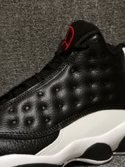 Close-up of the black textured upper, stitching, and red tongue accent