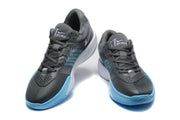 Pair of dark grey and light blue Nike G.T. Academy basketball shoes shown from the front.