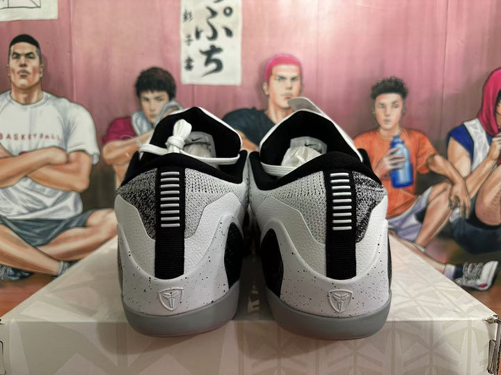 Rear view of black, white and grey basketball sneakers showing padded collars, heel pull tabs and textured heel panels.