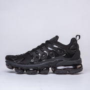 Side profile of a black Nike-style sneaker with a segmented sole.