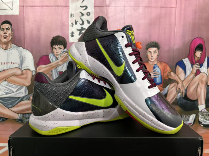 Pair of Nike basketball sneakers displayed at an angle, showing black, white, burgundy, and neon green panels with a speckled midsole.