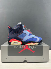 Side profile of the blue, navy, red, black, and cream sneaker displayed on a Jordan shoebox.