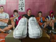 Front view of the white lace-up sneakers showing the tongues, toe boxes and layered panels.