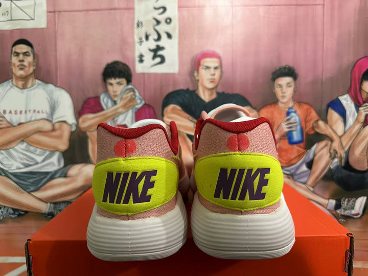 Rear view of pink Nike basketball shoes with volt heel panels, dark Nike lettering, and white ridged outsoles.