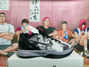 Side profile of a charcoal gray and black Nike basketball sneaker with a textured upper, black outsole, and gray midsole.